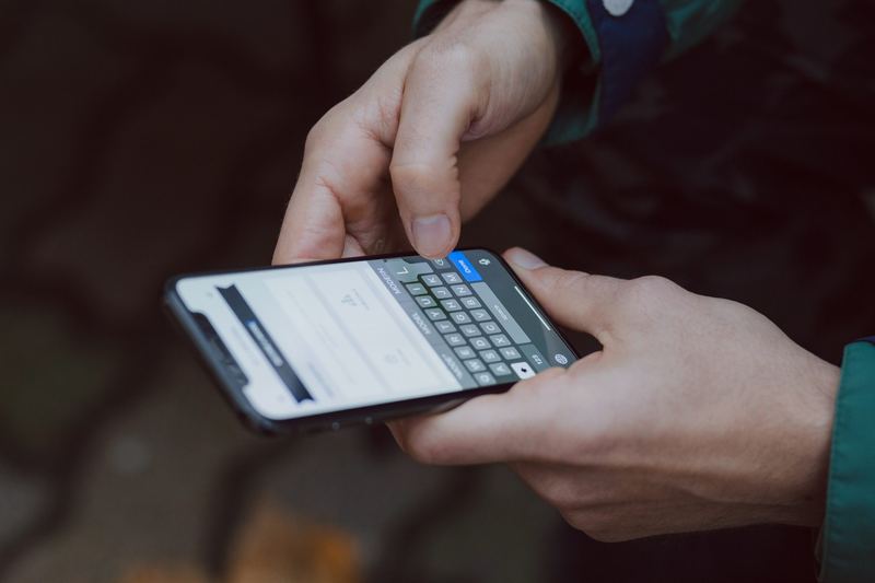 Hände tippen eine Nachricht auf einem Smartphone